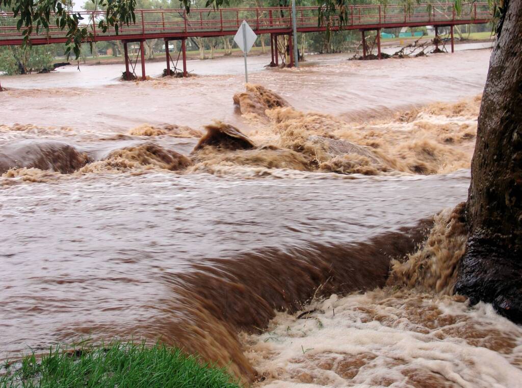 Water flowing swiftly over Undoolya Road causeway down into the Todd River, Alice Springs, 9 Jan 2010
