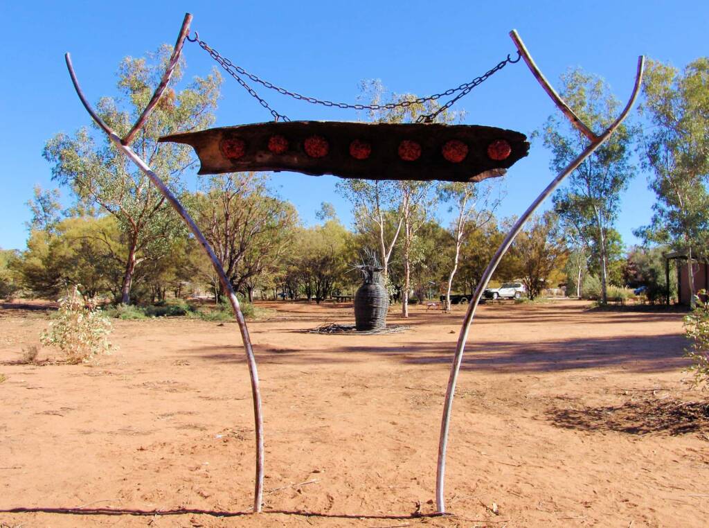 Untitled by artist J9 - (Yaninti seeds, burnt-out log, scrap metal, chain)