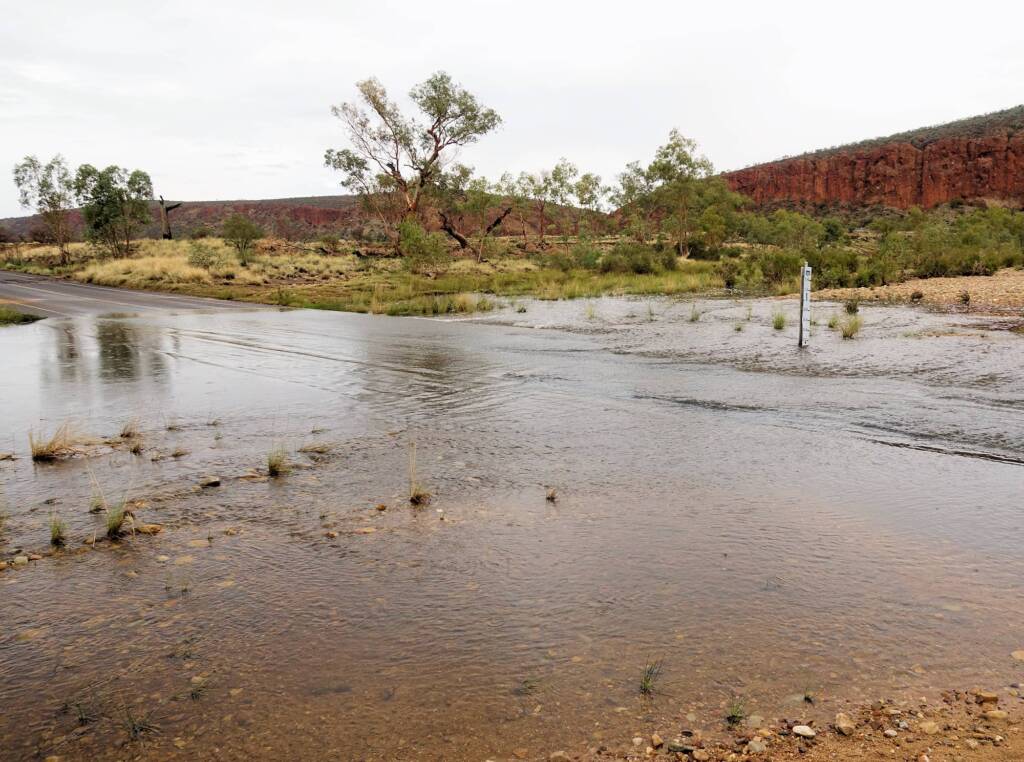 Finke River flowing across Larapinta Drive and heading down to Glen Helen Gorge, NT