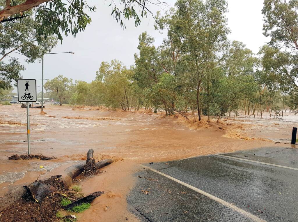 View of the raging Todd River across Palm Circuit, south of Heavitree Gap, Alice Springs, NT