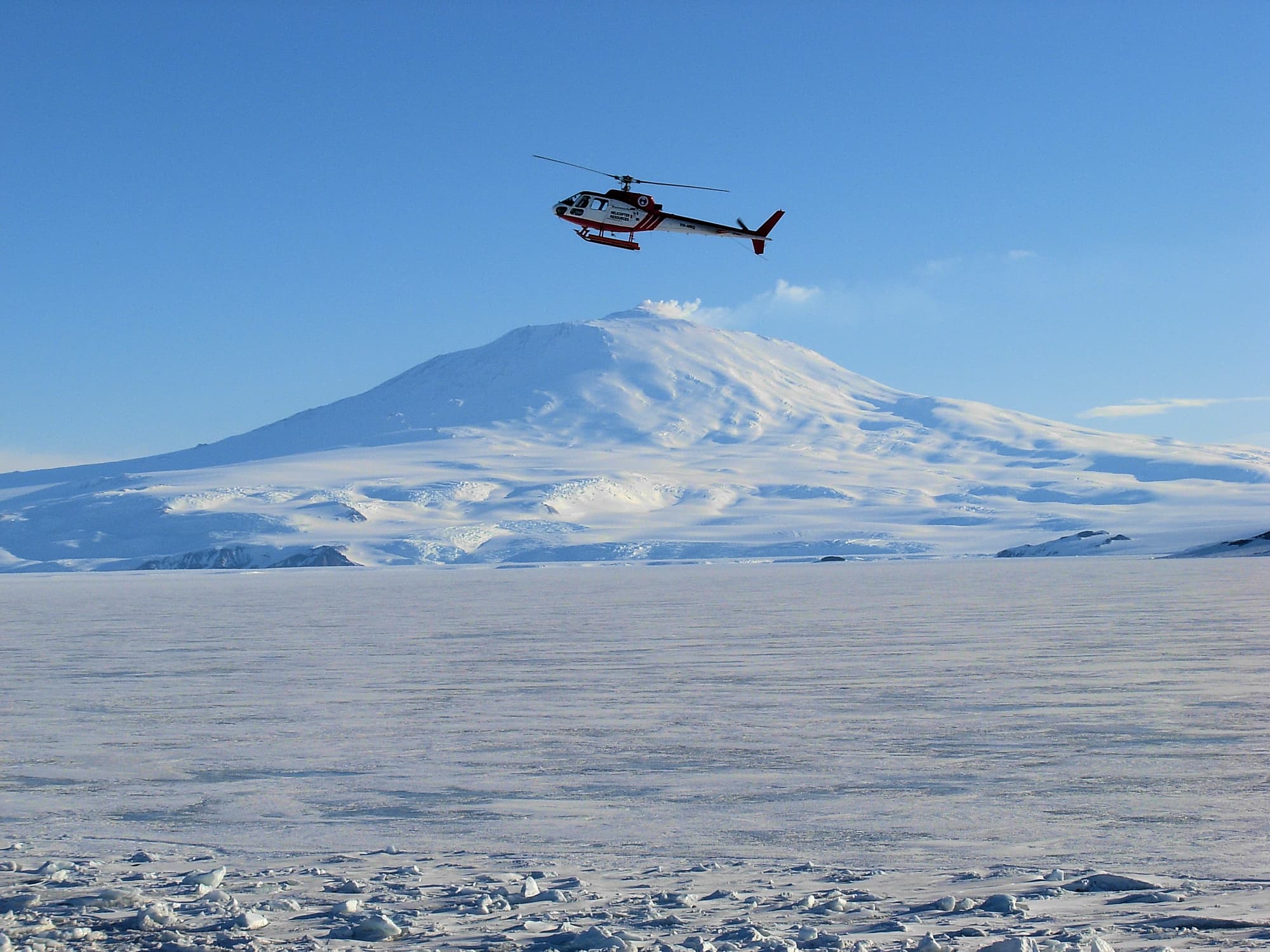 Mount Erebus and helicopter, Antarctica © Jennifer Cooke