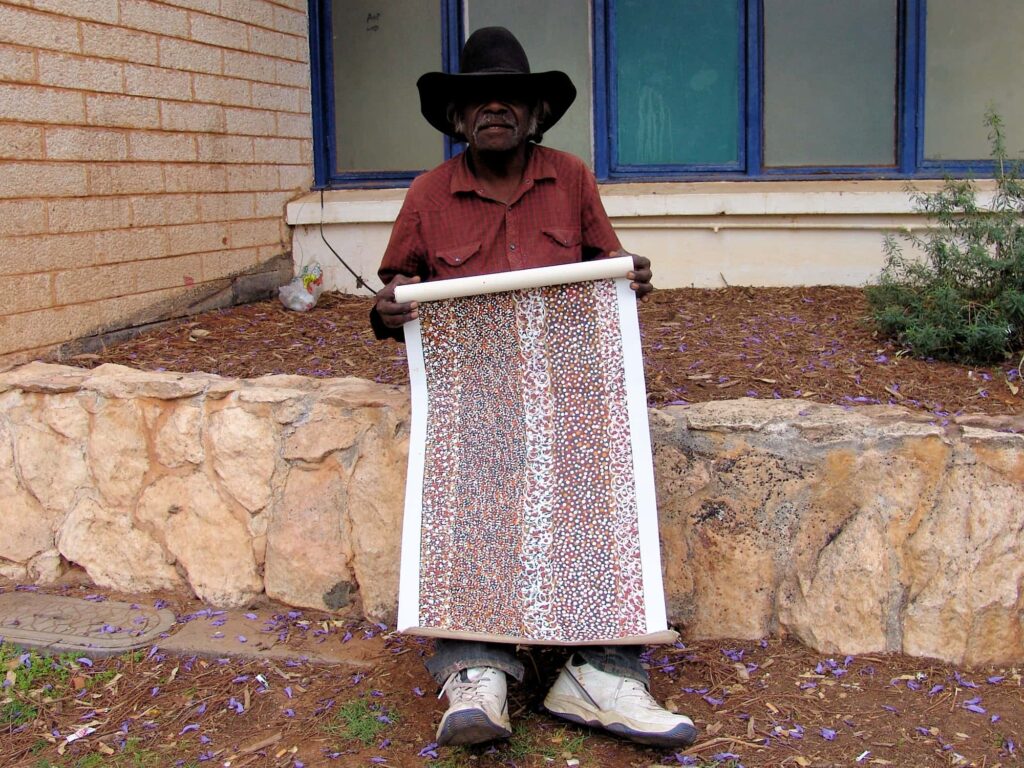 Keith Morgan Pitjara with his painting Bush Seed Dreaming, 2008