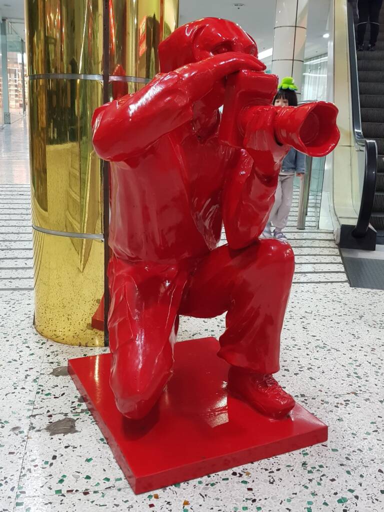 Red Paparazzi Dog (Bronze Sculpture with Red Powdercoat) by Gillie and Marc
